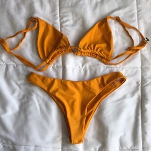 Small burnt yellow colored bikini. Not cheeky.